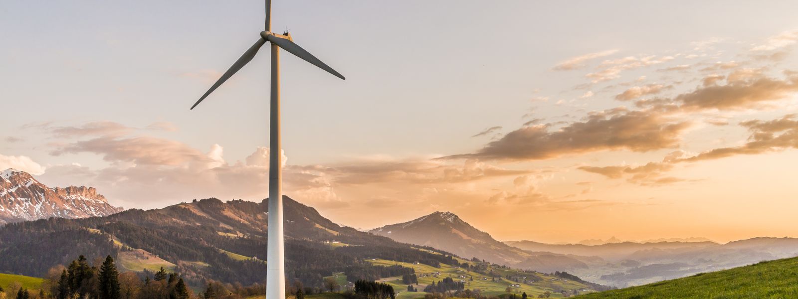 Turbina eolica al tramonto su paesaggio montano italiano